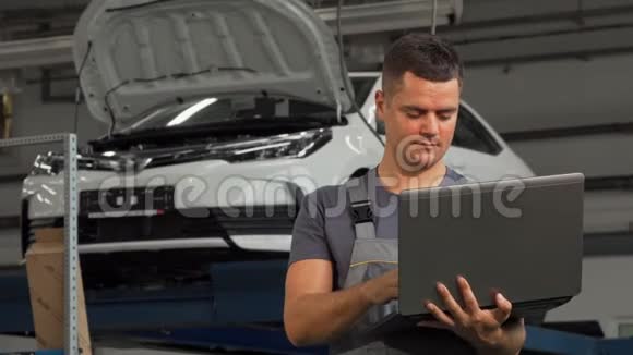 汽车修理工微笑着在笔记本电脑上工作时竖起大拇指视频的预览图