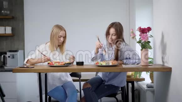 两个年轻的女人在家里聊天吃寿司最好的朋友在一起度过时间视频的预览图