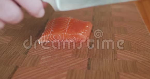 寿司主厨拿起一把刀用一把锋利的刀切下日本生鱼片和寿司用的脂肪肚三文鱼薄片视频的预览图