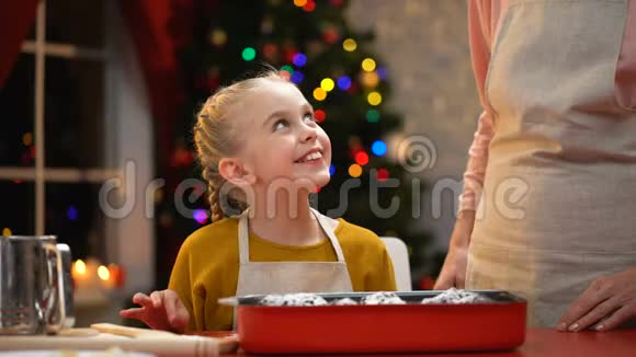 微笑的女孩偷偷品尝巧克力松饼圣诞节准备童年视频的预览图