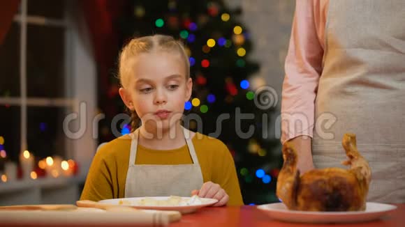 小女孩帮她奶奶端圣诞餐桌装饰品闪闪发光视频的预览图