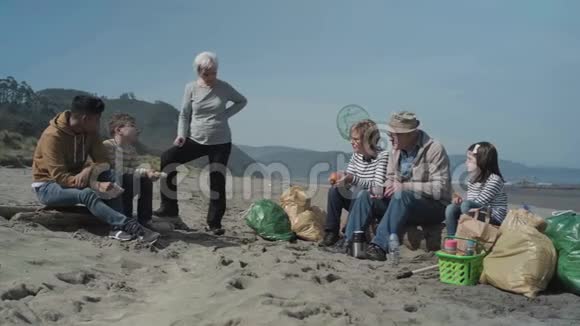 志愿者在清理海滩后休息视频的预览图