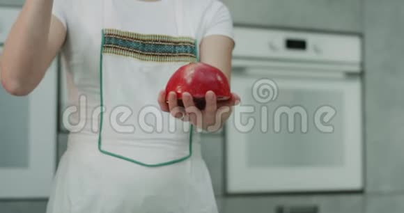 女人在厨房特写的时候抱着一个石榴用一个来展示石榴是多么容易打开和清洁慢慢慢慢视频的预览图