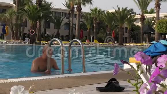 在度假酒店里走出室外游泳池的男人视频的预览图