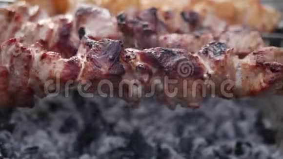 关闭旋转的串烤架上的猪肉肉片被炸了在剩下的时间里煎烤肉片视频的预览图