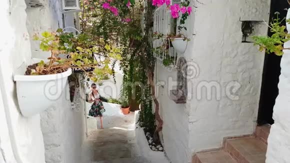 年轻美丽的女孩游客走过古老狭窄的城市街道拍摄外部的照片夏日晴天视频的预览图