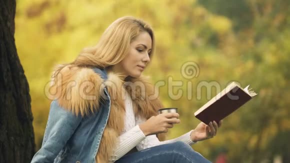 女性在看书的时候从保温杯中喝暖饮料视频的预览图