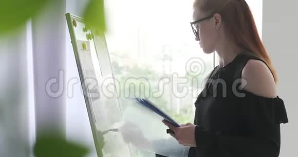 女商人在办公室白板上写笔记视频的预览图