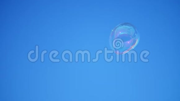 特写镜头一个大肥皂泡在蓝天上飞舞视频的预览图