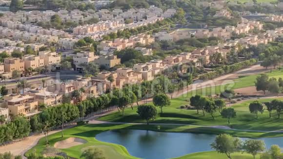 带高尔夫球场绿色草坪和湖泊的别墅和房屋的空中景观视频的预览图