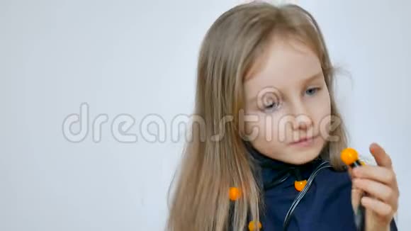 可爱的女孩子金发碧眼戴着一束白色背景的黄色圣诞灯视频的预览图