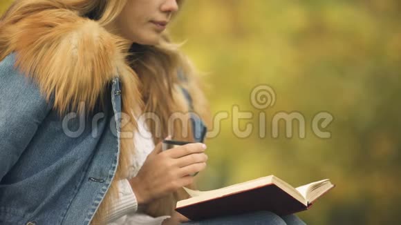 女人在后院看书喝茶享受秋天的天气享受快乐视频的预览图