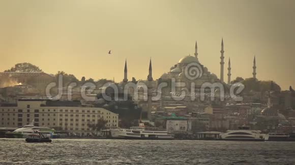 带着土耳其伊斯坦布尔古老历史建筑的海景日落时分在阳光下的Suleymaniye清真寺慢慢视频的预览图