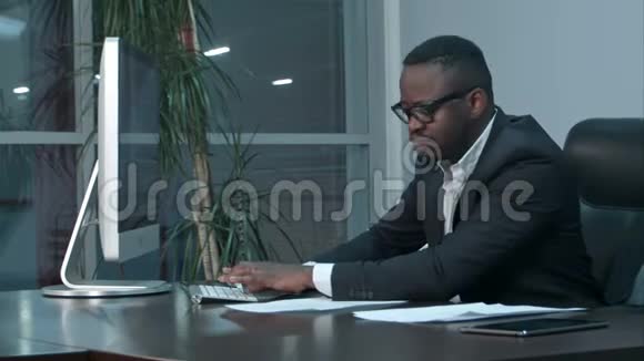 英俊的美国黑人商人在办公室里用笔记本电脑工作和打字视频的预览图