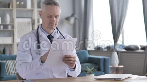 高级医生阅读医疗报告视频的预览图