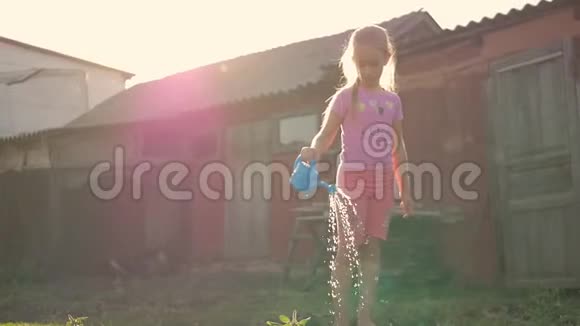 夏天日落时分小女孩在花园里浇水视频的预览图
