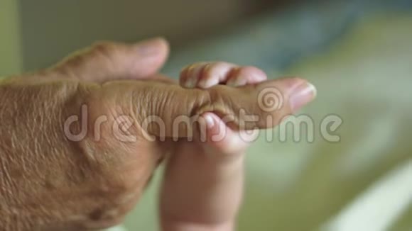 美丽的慢动作婴儿的手指握着祖父手指视频的预览图