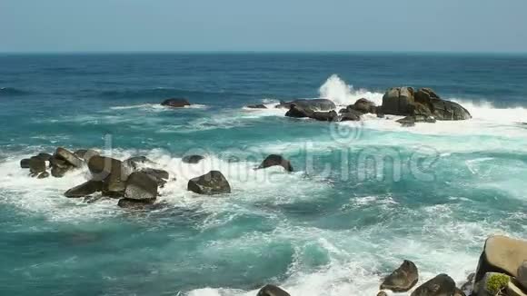 阳光明媚的一天大海岩石和海浪视频的预览图