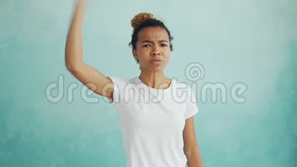 愤怒的混血女人站在浅蓝色一边说话和手势表达负面情绪的肖像视频的预览图