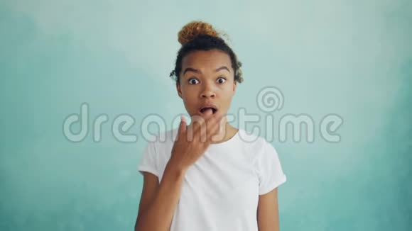 一幅令人惊讶的非裔美国女士抬起眉毛用手捂住她张开的嘴表达了她的惊讶之情视频的预览图