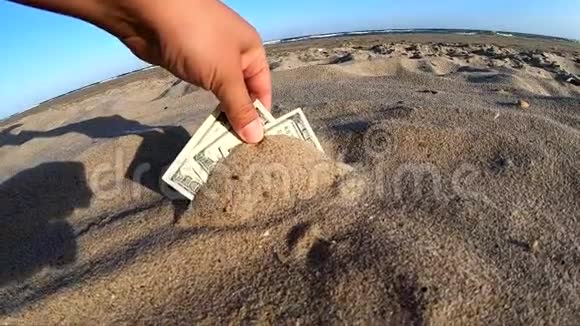 一个女孩从沙子里拿出三百美元的钞票视频的预览图