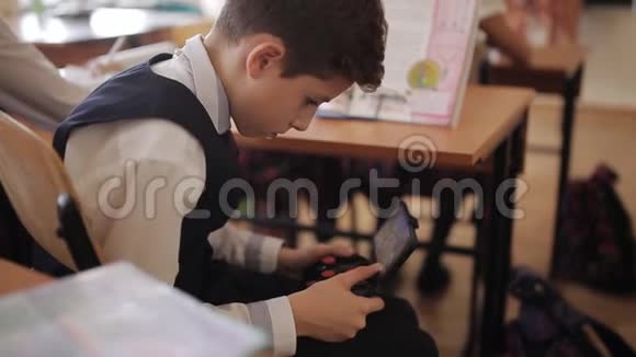 班上的学生在桌子下面玩控制器学生在桌子下面玩你的电话视频的预览图