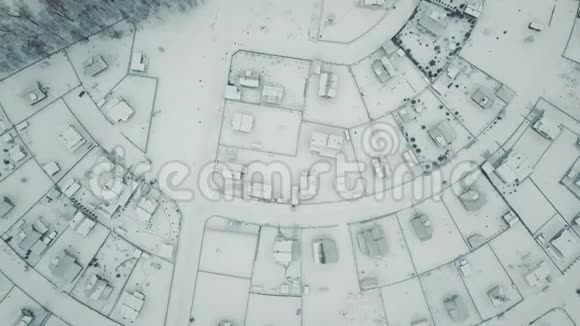 空中旋转拍摄顶部景色美妙的冬季村庄屋顶被雪覆盖视频的预览图