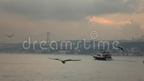 在博斯普鲁斯海峡的一艘旅行船背景是黄昏的日落多云的天空土耳其伊斯坦布尔视频的预览图