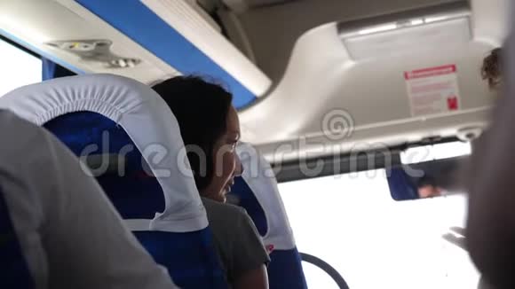 年轻女子乘公共汽车与旅客交谈下一个座位视频的预览图