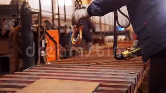 一个人用起重起重机工作末端有一个钩子在金属平面上的钩子视频的预览图
