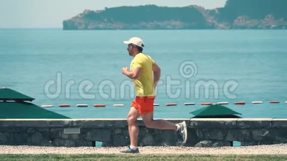 一个白人男子在海景中奔跑的慢镜头视频的预览图