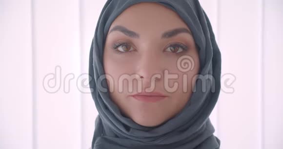 阿拉伯年轻漂亮女商人戴头巾的特写镜头看着镜头幸福地笑着穿着白色衣服视频的预览图