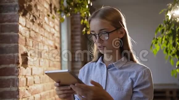 办公室里戴眼镜和平板电脑一起工作的女商人很累使用无线网络的白人年轻女学生肖像视频的预览图