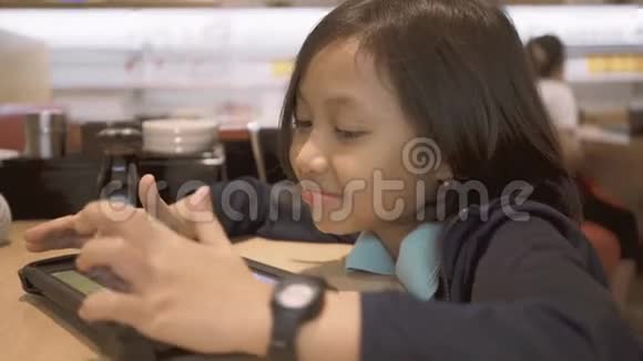 小女孩在咖啡馆用手机视频的预览图
