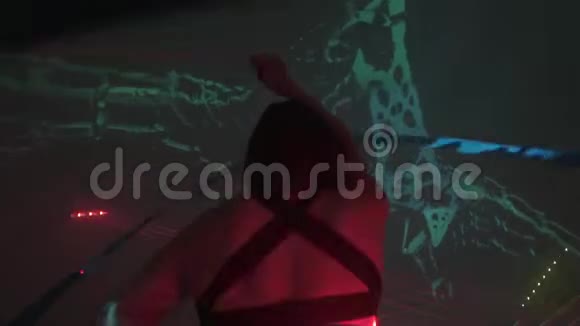 一场激光表演在城市投影背景上用丝带从事体操运动的瘦女人视频的预览图