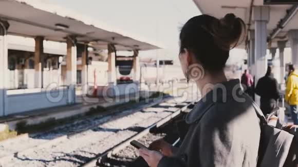 年轻的欧洲女商人在火车站用智能手机打字压力大迟到火车经过视频的预览图