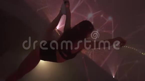 灵活的女体操运动员在夜总会里做麻绳和挥舞丝带动作缓慢视频的预览图