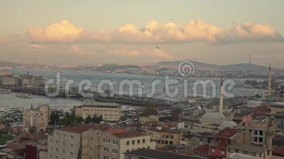 乘坐博斯普鲁斯海峡加拉塔大桥和旅游船飞越伊斯坦布尔市区晴朗多云的天空视频的预览图