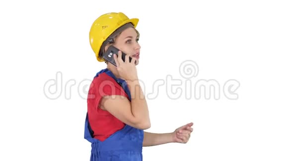漂亮的年轻建筑工女戴着黄色的安全帽在白色的背景上打电话视频的预览图