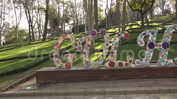 土耳其伊斯坦布尔绿树背景下一个宁静的城市公园里巨大的混凝土彩色字母GULHANE全景视频的预览图