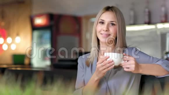 迷人微笑的女商人拿着大白杯享受休息喝咖啡的画像视频的预览图