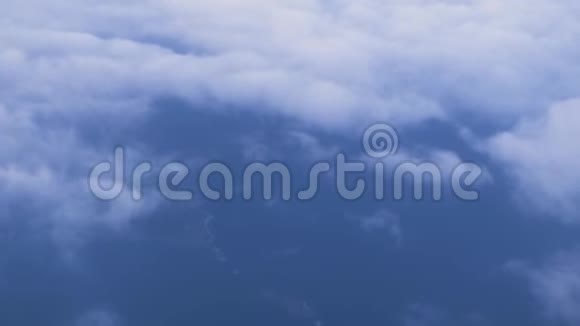 天空中的白云从窗户飞起的飞机俯瞰地球云景背景从飞机窗口可以看到空中景色视频的预览图