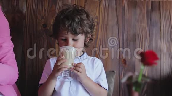 可爱的小男孩在咖啡厅品尝咖啡视频的预览图