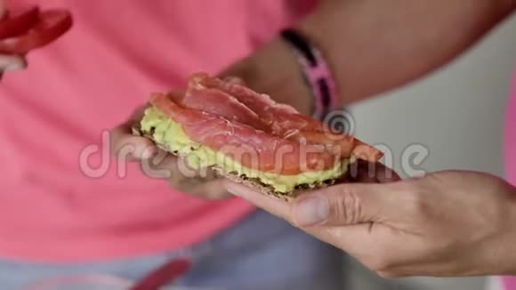 女性手握吐司用浅绿色牛油果糊铺视频的预览图