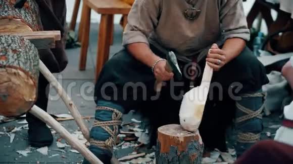穿着传统服装的木匠用斧头砍木头视频的预览图