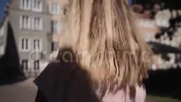 金发碧眼的年轻女子转过身来用头发摇着头后视视频的预览图