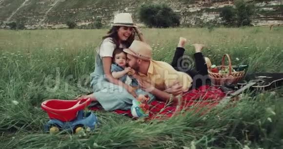 年轻的家庭和一个小男孩在一起野餐玩得很开心视频的预览图