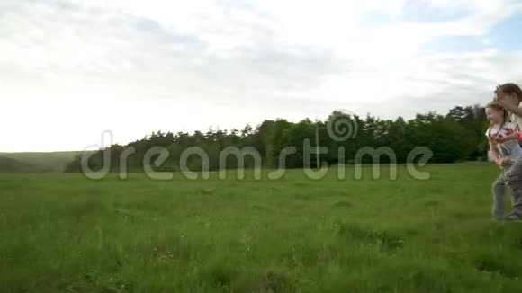 两个姐妹在草地上奔跑嬉戏视频的预览图