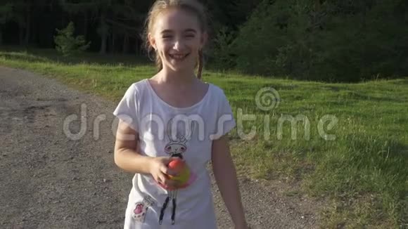 可爱的女孩走路吃苹果视频的预览图