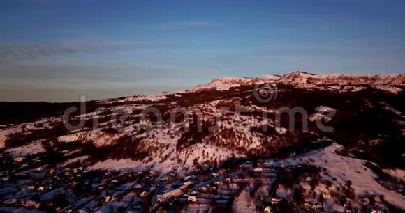 俄罗斯普塞拜日出时村庄雪山的空中全景视频的预览图